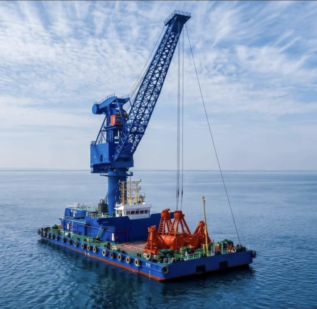 ABAS floating crane with grab discharging bulk cargo to a bulk carrier at anchorage